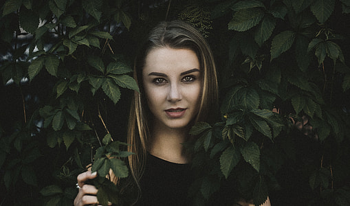 woman wearing black crew-neck top near green leaf plant thumbnail