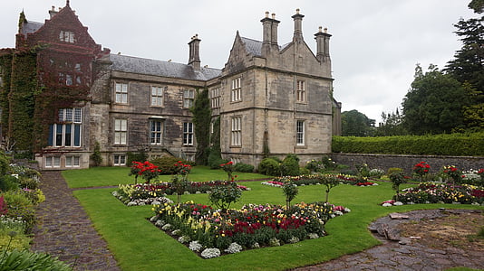 gray concrete mansion surrounded by flowers during daytime thumbnail