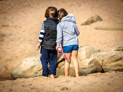 boy and girl walking on sand thumbnail