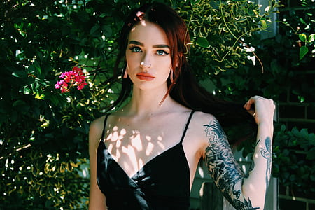 woman standing beside green plants thumbnail
