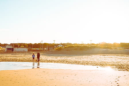 two person standing near body of water outdoor during daytime thumbnail