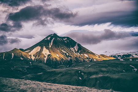 green and brown mountain under gray clouds during daytime thumbnail