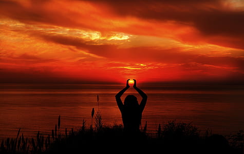 silhouette of person near body of water during sunset thumbnail