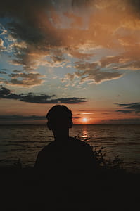 Silhouette Photography of Man Near Body of Water thumbnail