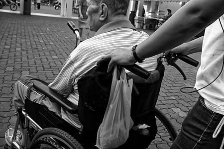 grayscale photo of man sitting in wheelchair thumbnail