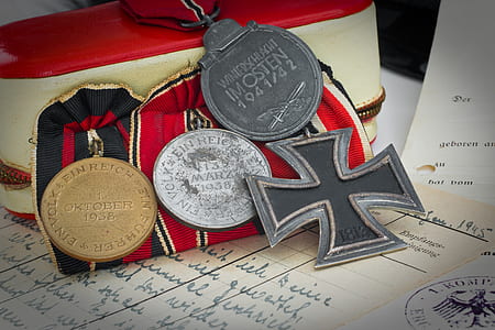silver-colored and gold-colored medals on white printer paper thumbnail