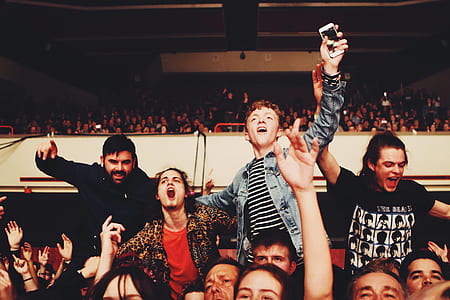 people raising their hands while cheering on bleachers thumbnail