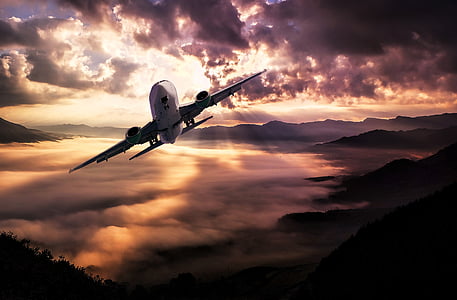 airliner in mid air above mountains thumbnail