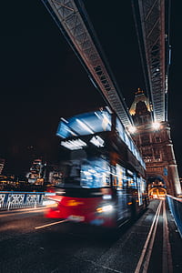 time lapse photo of red double-deck bus on road thumbnail