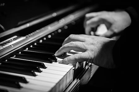 gray-scale photo of person playing a piano thumbnail