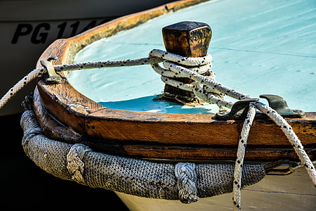 white and brown boat with gray rope parked at daytime thumbnail