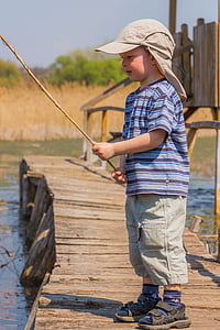 boy in blue and black stripe shirt holding fishing rod thumbnail