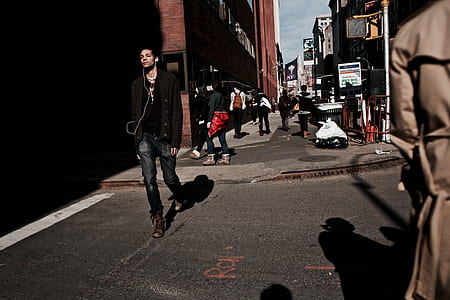 man walking on street in between buildings at daytime thumbnail