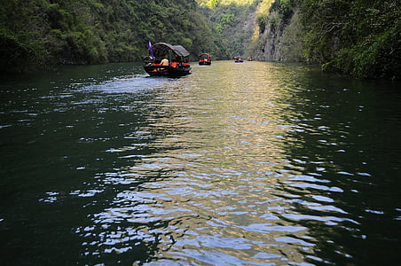 people on boat near body of water between mountain during daytime thumbnail