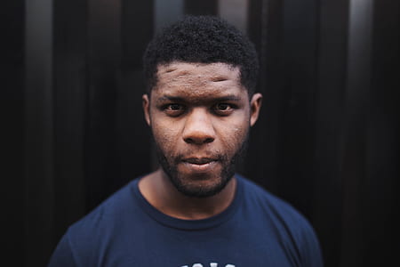 man standing behind black and gray background thumbnail