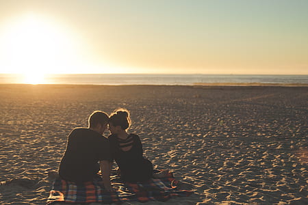 man and woman looking at each other on beach during sunset thumbnail