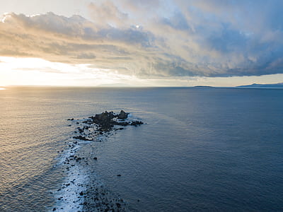 wide angle photo of body of water under cloudy skyt thumbnail