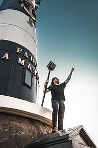man standing near lighthouse thumbnail