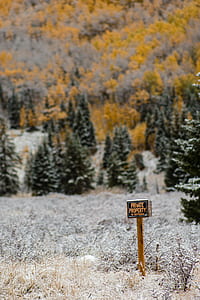 brown and black private property signboard near snow covered grass at daytime thumbnail