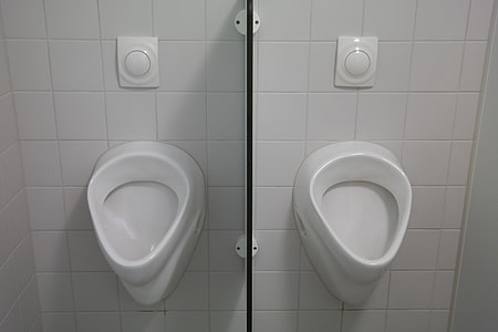 two white toilet bowls on white wall thumbnail