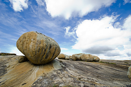 brown rock under white cloudy sky at daytime thumbnail
