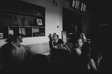 grayscale photo of people sitting inside room thumbnail