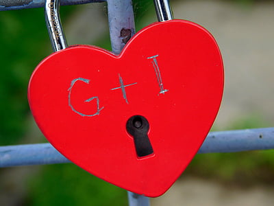 red padlock on gray metal fence thumbnail