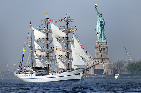 photo of white sailing ship near Statue of Liberty thumbnail
