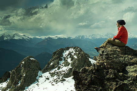 person sitting on mountain cliff thumbnail