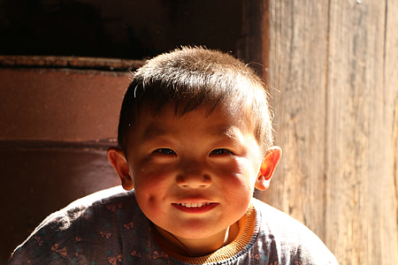 boy standing beside wooden wall thumbnail
