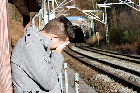 man leaning on brown wall holding his face thumbnail