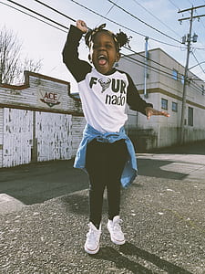 girl raising her hand during daytime thumbnail