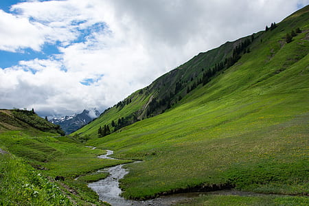 landscape photography of mountains under white clouds thumbnail