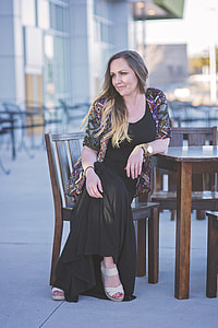 woman wearing black dress sitting on chair thumbnail