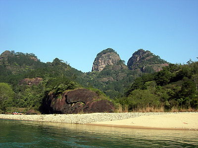 cliff mountain covered with green leafed trees under clear blue sky thumbnail