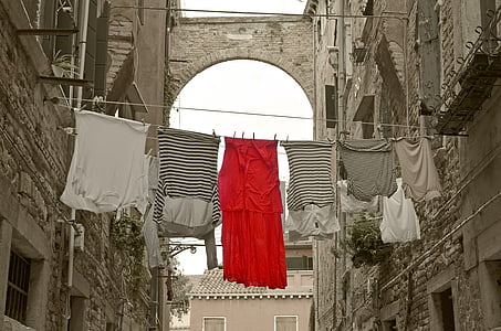 assorted-color clothes hanging between buildings thumbnail