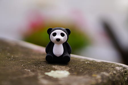 white and black panda figurine on brown surface thumbnail