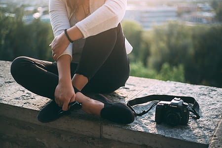 Woman Sitting Beside Black Canon Dslr Camera thumbnail