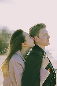 Woman Kissing the Back of Man's Ear Near Sea thumbnail