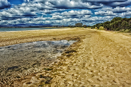 Beach with clouds in the sky in Tasmania, Australia thumbnail
