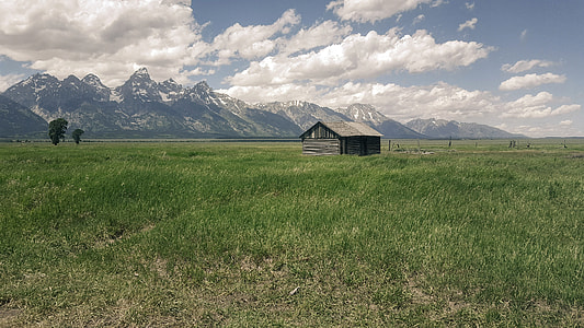 Beautiful Landscape with grassland and Mountains with Cabin under sky and clouds thumbnail