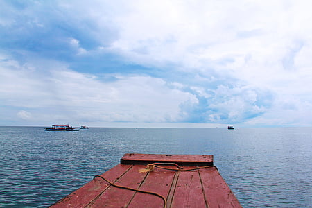 photography of calm sea under cloudy sky thumbnail