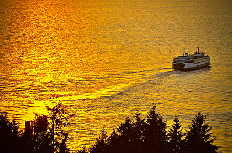 ferry boat on body of water during golden hour thumbnail