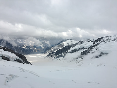 snow covered mountains under cloudy sky during daytime thumbnail