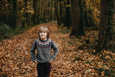 child standing on dried leaves thumbnail