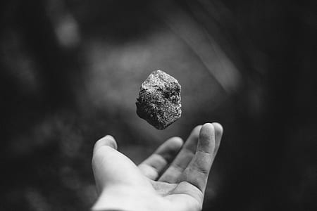 grayscale photo pf person catching stone thumbnail