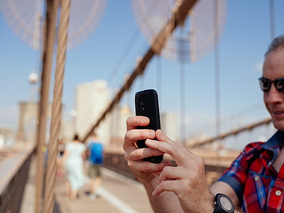 man using smartphone on bridge thumbnail