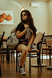 woman sitting on brown wooden chair thumbnail