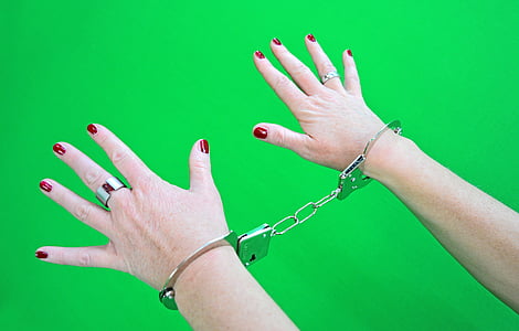 person wearing gray metal handcuff thumbnail