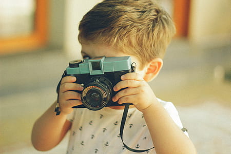 boy holding camera taking picture thumbnail